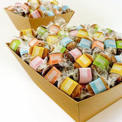 Good Karmal Spring Baskets are shown with caramel wrapped in pastel colors for spring: green, pink, blue, orange and yellow. Caramels shown say, Good Fortune, Good Karma, Good Times, Good Quotes and Good Vibes.