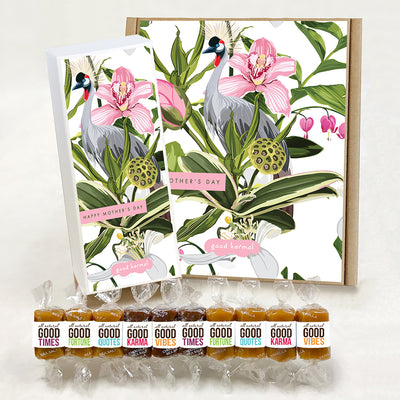 Good Karmal caramel gift boxes that feature a beautiful botanical print with cranes and irises, and the words, "Happy Mother's Day." Caramels shown are wrapped in positive words, Good Times; Good Fortune; Good Quotes; Good Karma; and Good Vibes. Sea salt, Chocolate Sea Salt and Vanilla caramels.