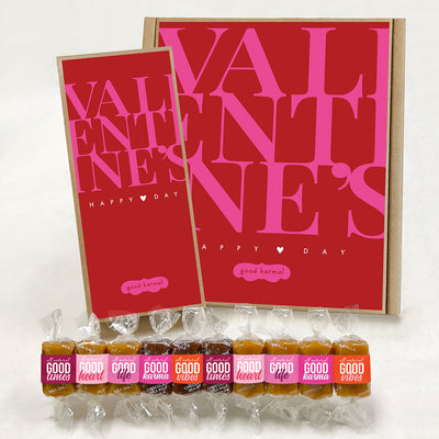 Good Karmal Valentine gift boxes in pink and red with the words "Valentine's Happy Day" and an assortment of pink and orange caramels wrapped in Good Times, Good Heart, Good Life, Good Karma and Good Vibes.