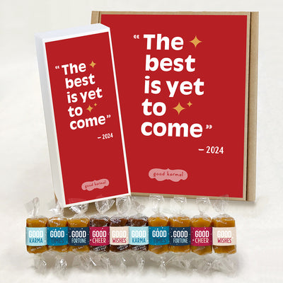 Multi-flavor caramel holiday gift box filled with caramels wrapped in positive quotes and good cheer, good wishes, good fortune, good times and good karma. The outside of the red white gift box says, "The best is yet to come" - 2024. These are Good Karmal's holiday caramels.