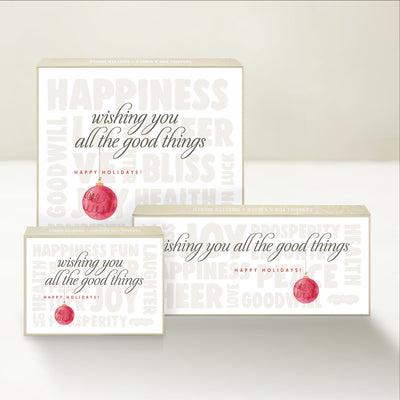 Three holiday-themed Good Karmal caramel gift boxes wishing you happy holidays and all the good things, including happiness, prosperity, health, and more. 