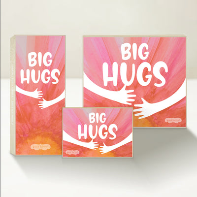 Three Good Karmal caramel gift boxes that say "Big Hugs," with the silhouette of arms reaching out in an embrace on a pastel background.