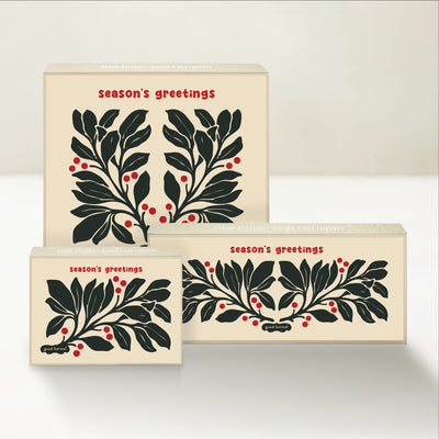 Three holiday-themed Good Karmal caramel gift boxes with a vintage-inspired botanical illustration wishing season's greetings. 