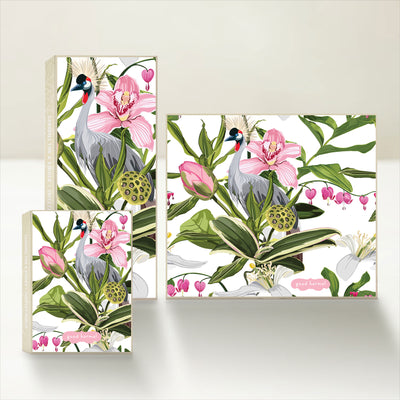 Three Good Karmal caramel gift boxes with an illustration of a crane bird set amid assorted tropical plants and flowers on a white background.