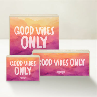 Three Good Karmal caramel gift boxes that say "good vibes only" on a pastel background. 