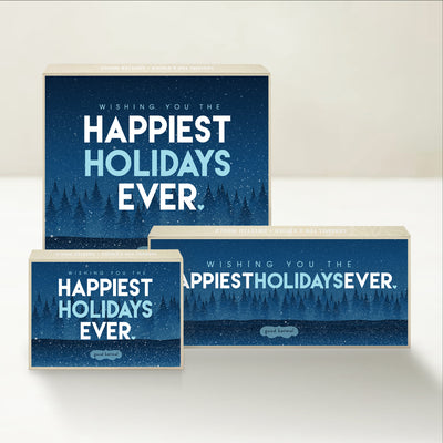 Three holiday-themed Good Karmal caramel gift boxes featuring a snowy landscape and "happiest holidays ever" wishes.