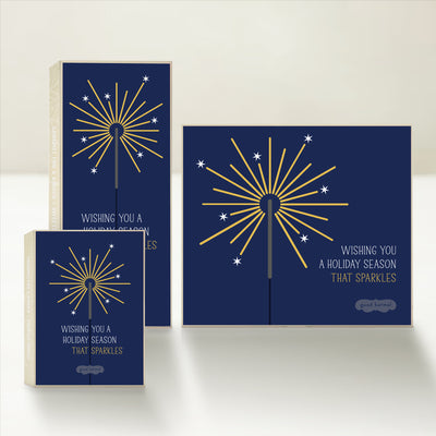 Three holiday-themed Good Karmal caramel gift boxes featuring an illuminated sparkler and wishing you a holiday season that sparkles. 