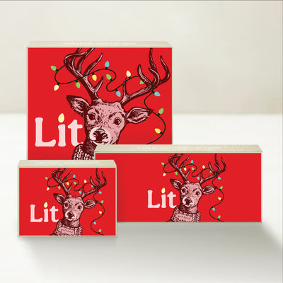 Three holiday-themed Good Karmal caramel gift boxes with an illustration of a playful reindeer wtih holiday string lights in its antlers. 