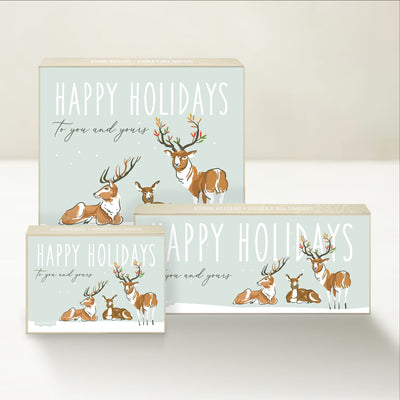 Three holiday-themed Good Karmal caramel gift boxes featuring a family of reindeer wishing happy holidays to you and yours.