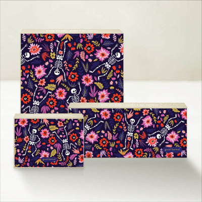 Three Good Karmal caramel gift boxes featuring playful skeletons and flowers.