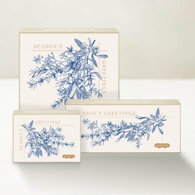 Three holiday-themed Good Karmal caramel gift boxes with a vintage-inspired botanical illustration wishing season's greetings.