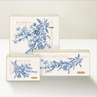 Three holiday-themed Good Karmal caramel gift boxes with a vintage-inspired botanical illustration wishing season's greetings. 